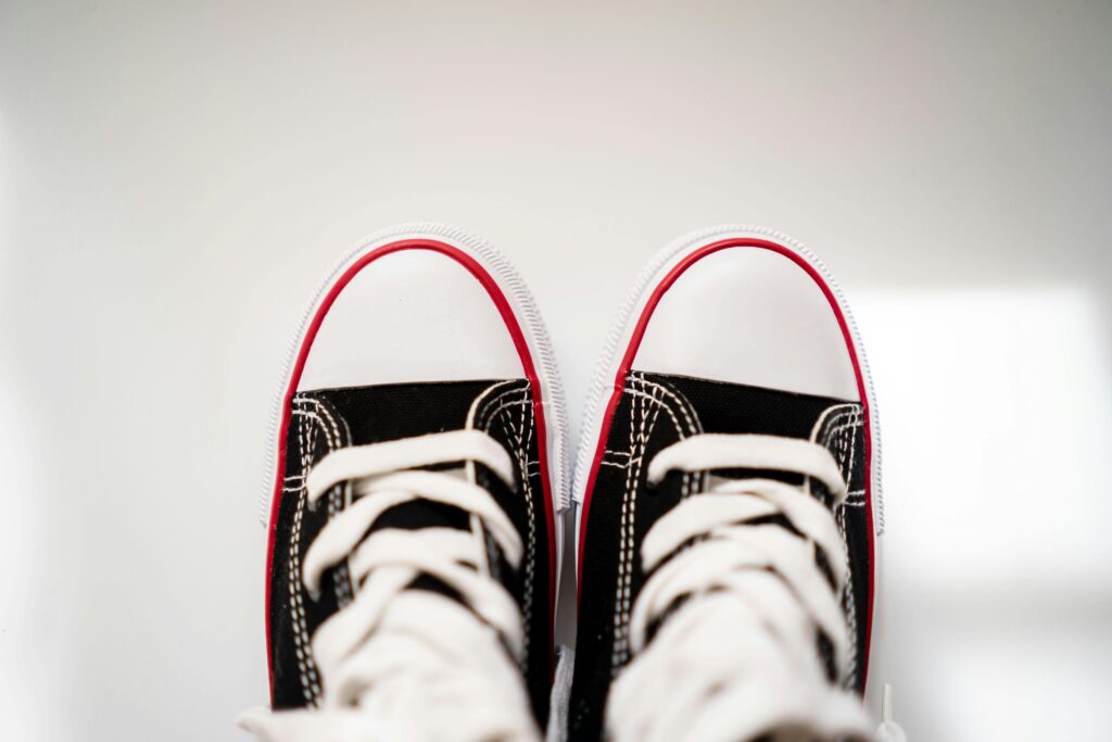 Black and white sneakers viewed from above, placed on a clean white surface with ample negative space.